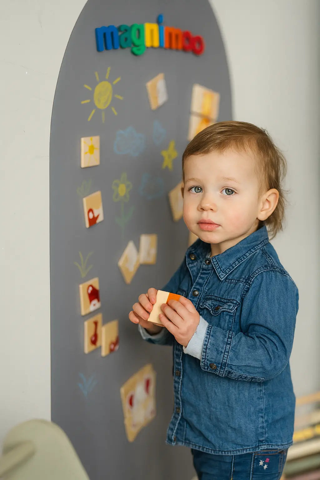 Toddler boy using Magnimoo magnet board in Elephant Grey arch style with learning magnets