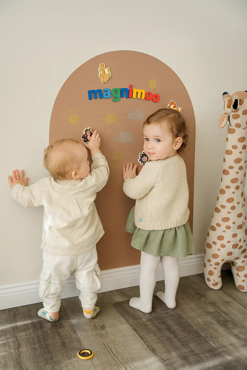 Two toddlers playing on Magnimoo magnet board in Brown Sugar arch design decorated with animal magnets